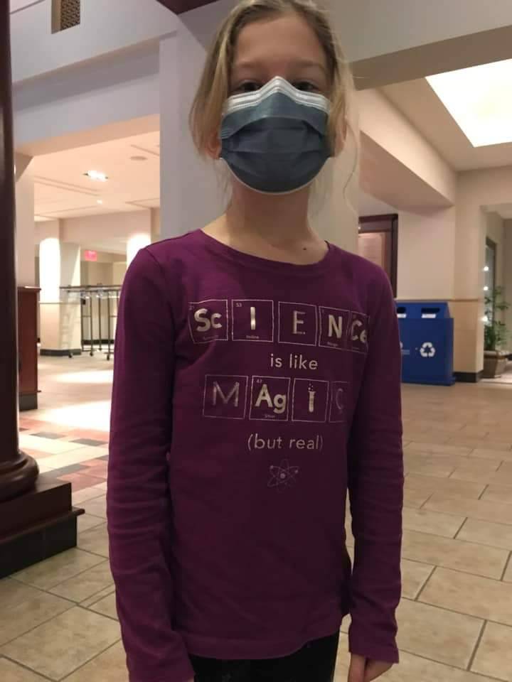 A young girl wears a "Science is like magic (but real)" shirt to hear Col. Collins speak.